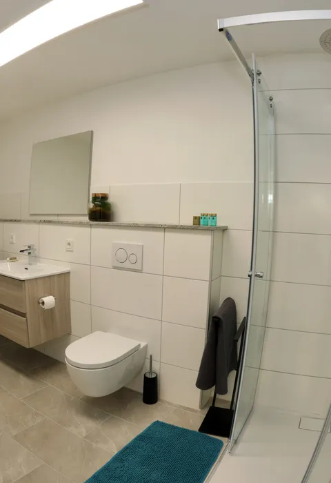 Badezimmer mit Waschmaschine, Trockner und Regendusche
