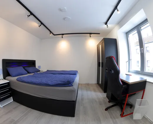 Schlafzimmer mit Boxspringbett, Kleiderschrank und Arbeitsplatz